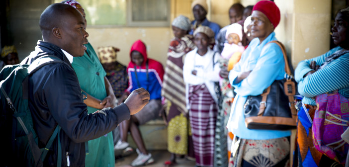 A man with a back pack speaks to a group of women.