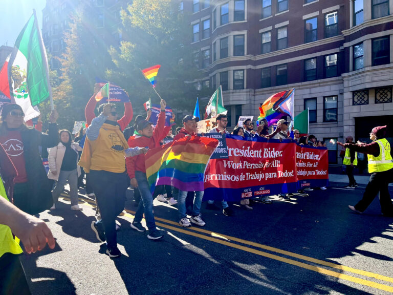 People marching down the street with rainbow flags